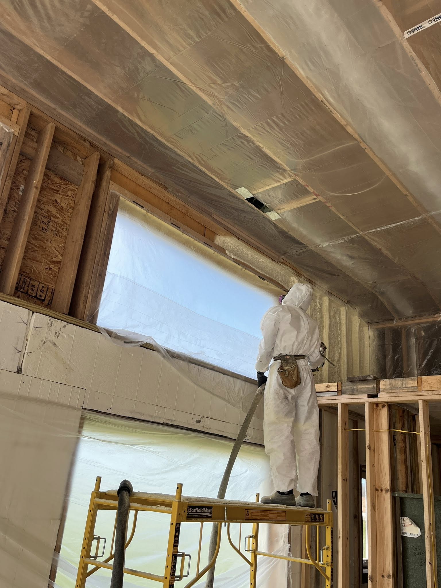 Spray foam contractor applying ceiling insulation in Northeast Wisconsin